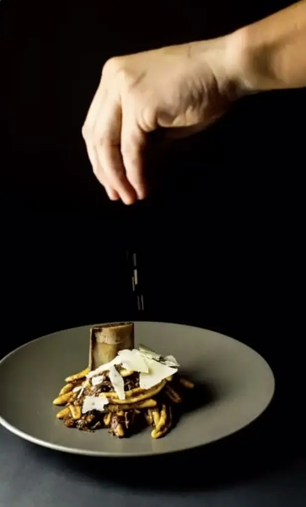 Chef Paul Aceto finishing cavatelli with bone marrow and shaved Parmigiano